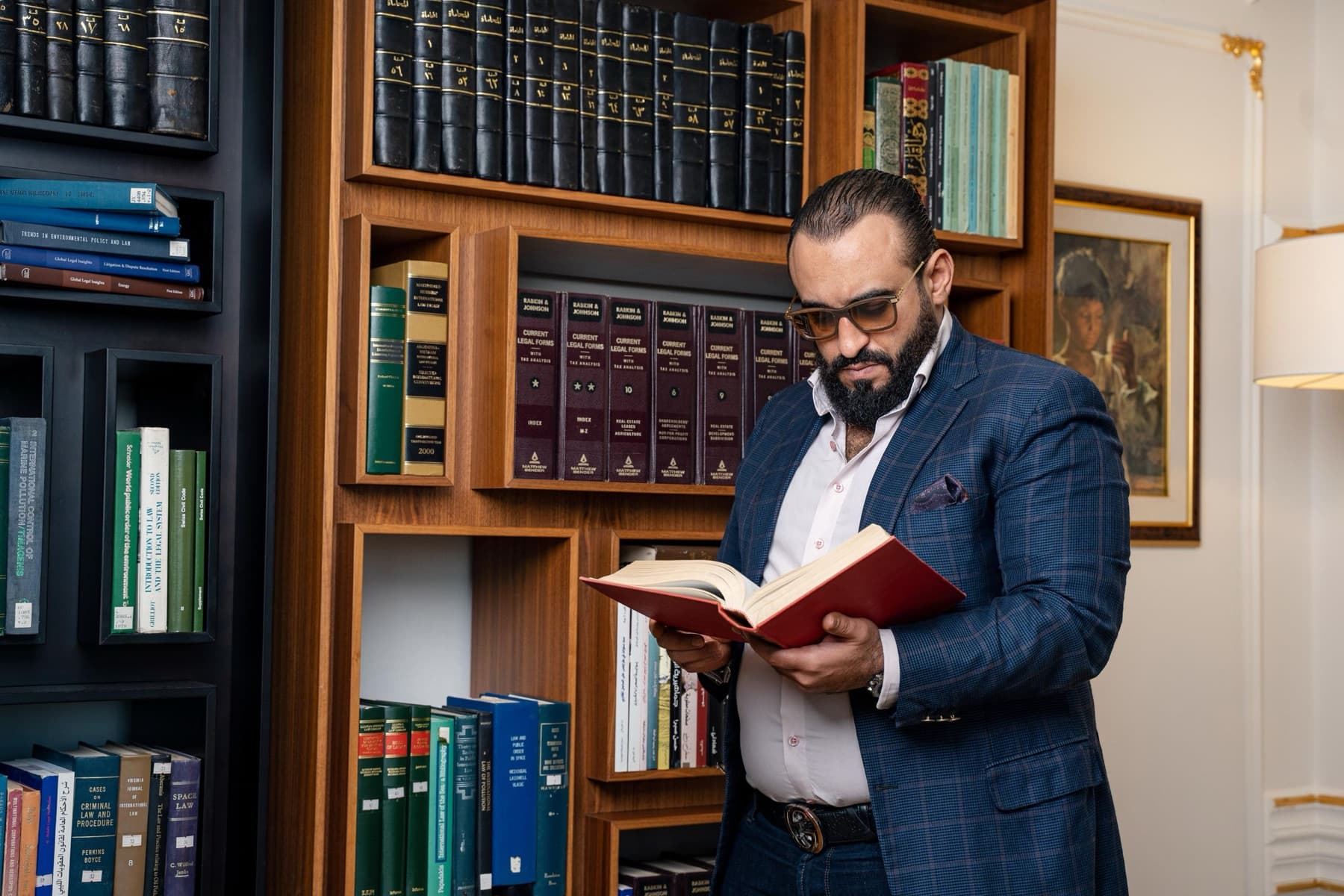 Lawyer reading a law book in the firm's library